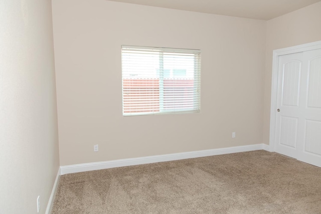 carpeted spare room with baseboards