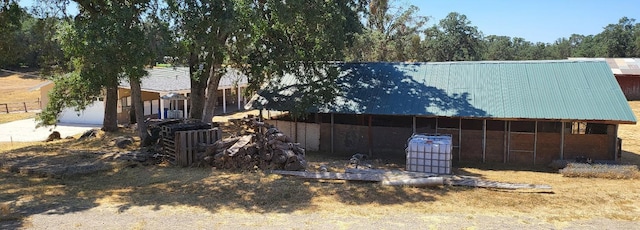 view of side of property featuring metal roof and an outdoor structure