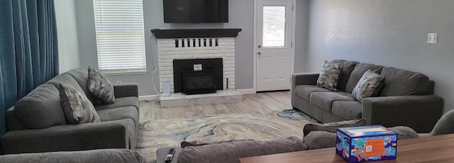 living room with wood finished floors, a fireplace, and baseboards