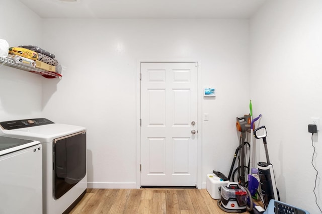 laundry area featuring baseboards, washing machine and dryer, laundry area, and light wood-style flooring