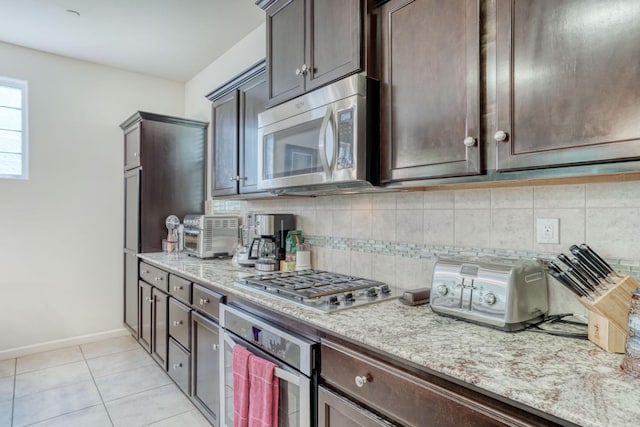 1525 N Piccadilly Ln, Clovis, CA 93619 - kitchen with dark brown cabinets, light stone counters, appliances with stainless steel finishes, and decorative backsplash