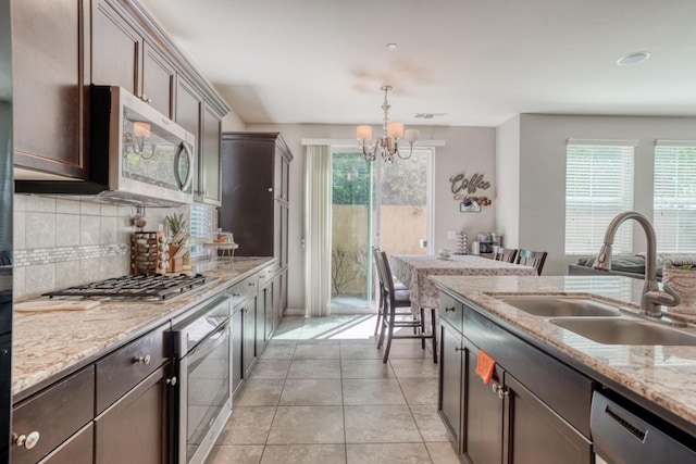 kitchen with a sink, a chandelier, a healthy amount of sunlight, and appliances with stainless steel finishes
