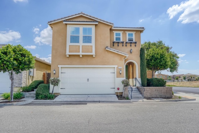 traditional home featuring driveway, stucco siding, a tiled roof, and a garage