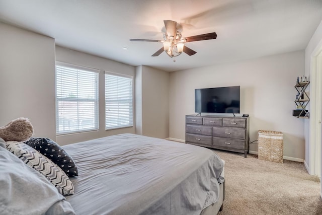 carpeted bedroom with baseboards and a ceiling fan
