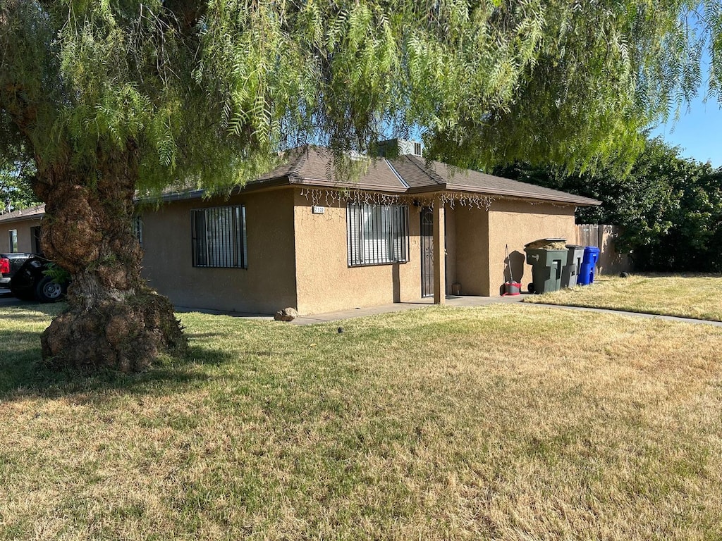 3204 E E Ter, Fresno, CA 93703 - view of side of property with stucco siding and a lawn