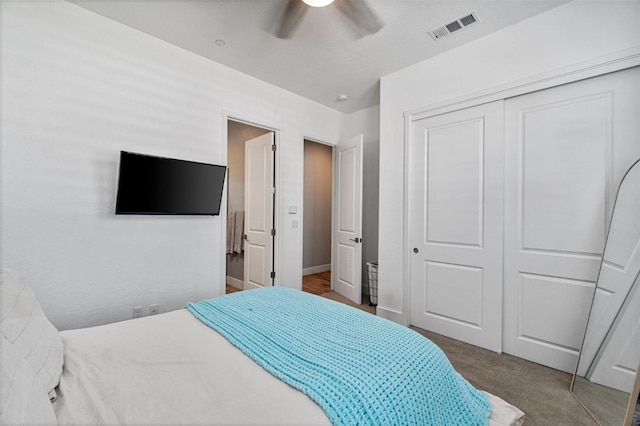 bedroom with a closet, ceiling fan, carpet, and baseboards