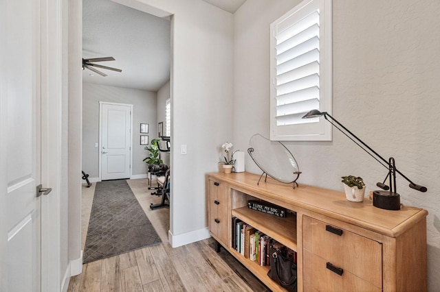 foyer featuring light wood-style floors, baseboards, and a ceiling fan