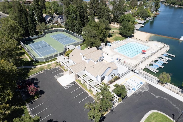 drone / aerial view of a nearby body of water and a pool area