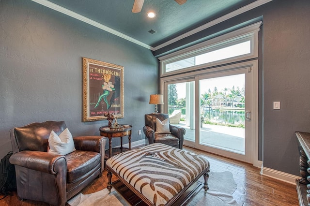 living area featuring baseboards, crown molding, a textured wall, and wood finished floors