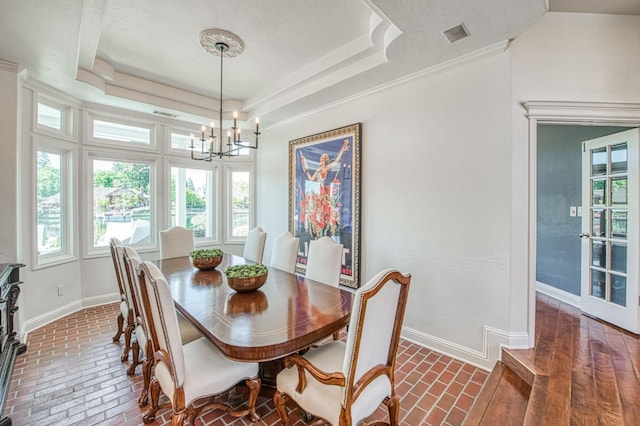 dining space featuring a chandelier, baseboards, and brick floor