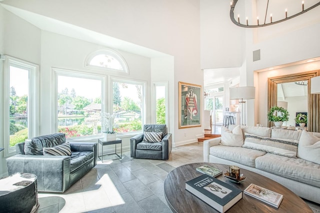 living area featuring a wealth of natural light, a high ceiling, and a notable chandelier