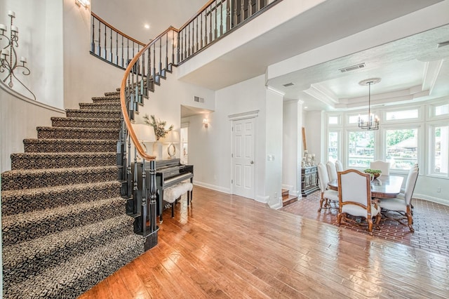 interior space featuring baseboards, stairs, hardwood / wood-style floors, and a notable chandelier