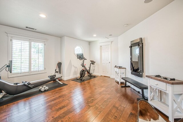 workout area with baseboards, recessed lighting, hardwood / wood-style floors, and visible vents