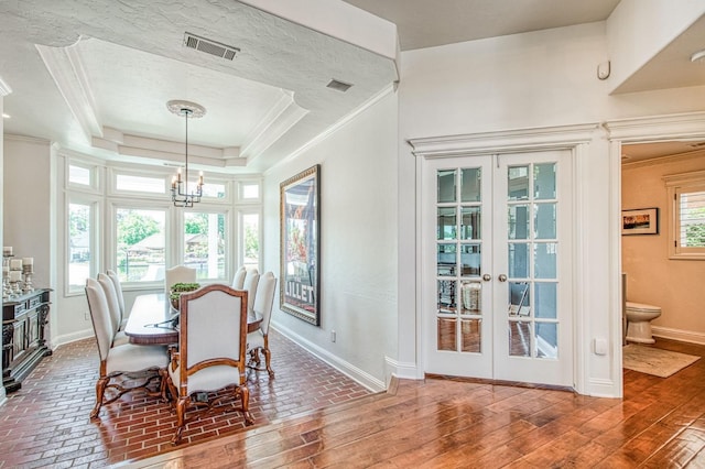 dining space featuring crown molding, baseboards, visible vents, and a chandelier