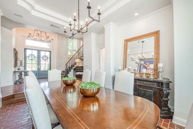 dining room featuring french doors, visible vents, stairway, a chandelier, and brick floor