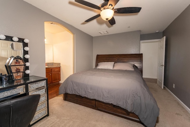 13375 Peach St, Parlier, CA 93648 - carpeted bedroom featuring ensuite bathroom, visible vents, arched walkways, a ceiling fan, and baseboards