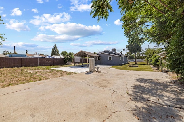 exterior space with a gazebo, fence, a patio area, driveway, and a carport