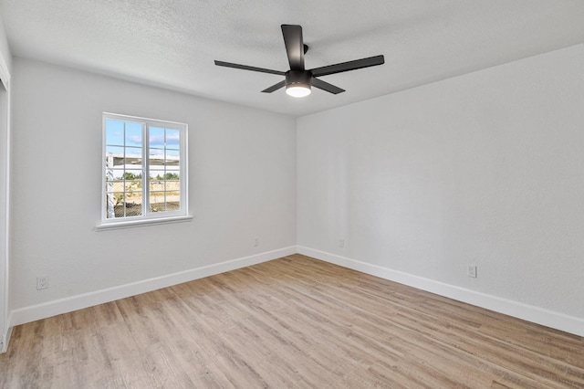 empty room featuring wood finished floors, baseboards, and ceiling fan