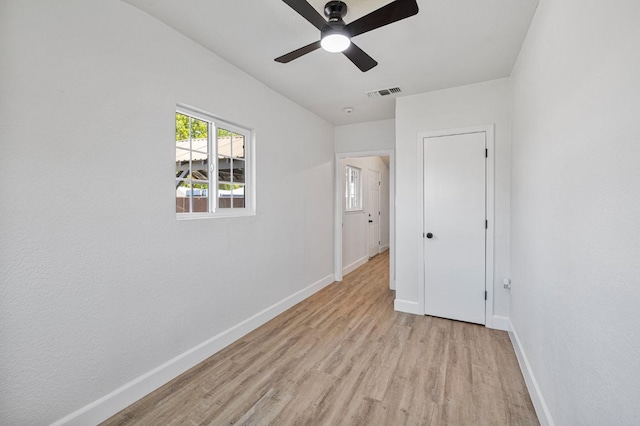 unfurnished bedroom featuring baseboards, light wood-style floors, visible vents, and a ceiling fan