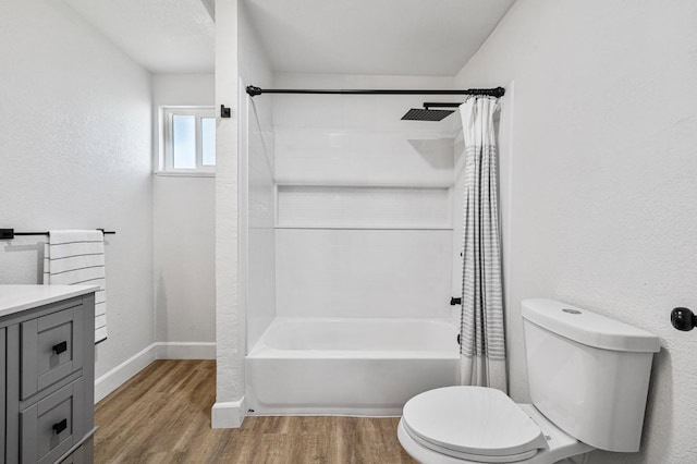 bathroom featuring toilet, baseboards, shower / bath combo with shower curtain, and wood finished floors