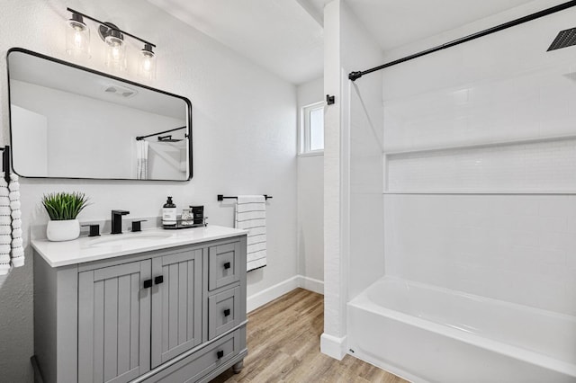 bathroom with vanity, baseboards, shower / bathtub combination with curtain, and wood finished floors