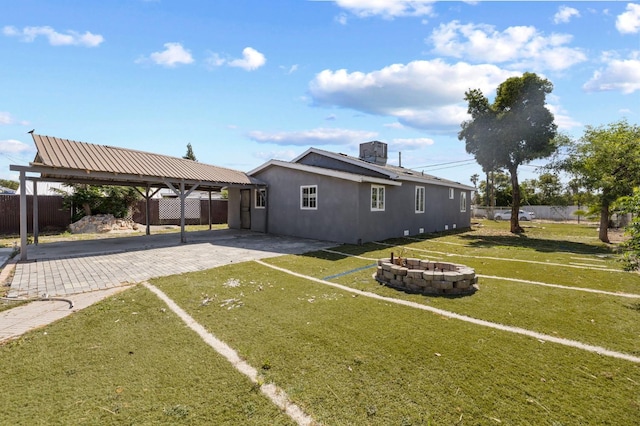 2194 N Feland, Fresno, CA 93722 - back of property with a fire pit, driveway, and stucco siding