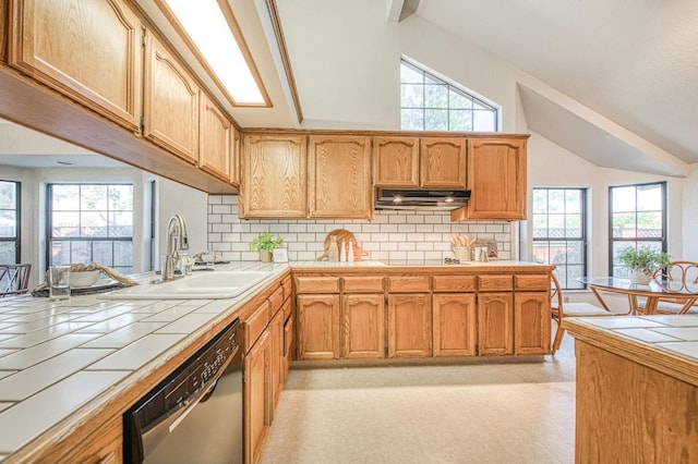 kitchen with lofted ceiling, tile countertops, a sink, and dishwasher