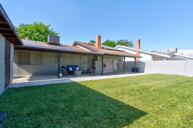 rear view of property with roof mounted solar panels, a patio area, central AC, and an outdoor living space