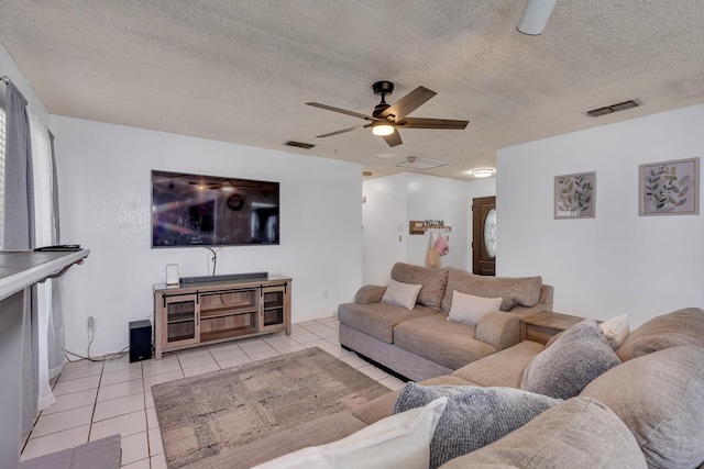 tiled living room with a ceiling fan and a textured ceiling