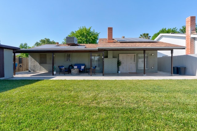 back of house with a patio area, roof mounted solar panels, central AC, and an outdoor living space