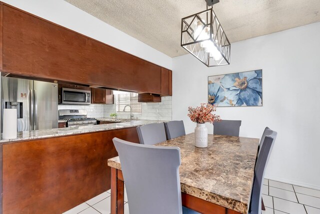 dining room with light tile patterned floors and a textured ceiling