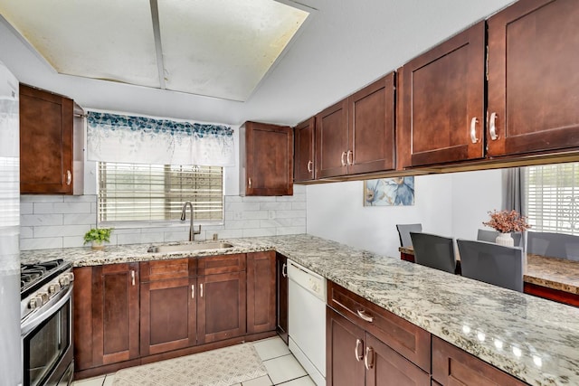 kitchen with a sink, stainless steel range with gas stovetop, dishwasher, backsplash, and light stone countertops