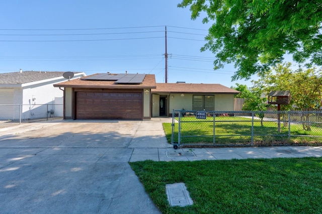 ranch-style home with a garage, solar panels, concrete driveway, stucco siding, and a gate