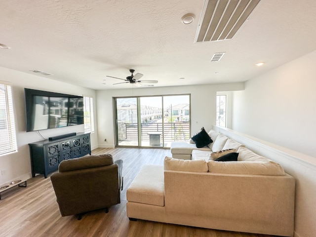 living room featuring light wood-style floors, a ceiling fan, baseboards, and recessed lighting