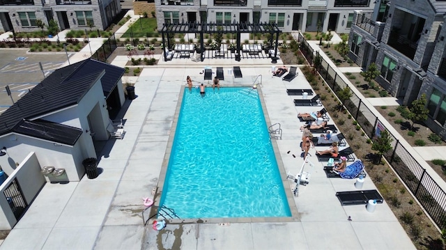 community pool with a patio area and fence