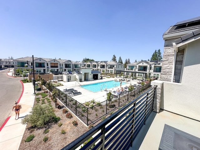 community pool featuring a residential view and fence