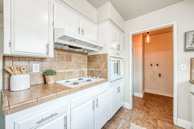 4693 E Church Ave, Fresno, CA 93725 - kitchen with white appliances, under cabinet range hood, white cabinets, and baseboards