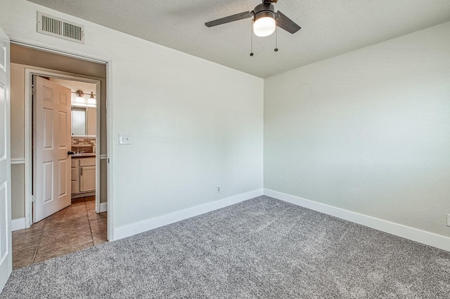 4693 E Church Ave, Fresno, CA 93725 - empty room with a ceiling fan, carpet floors, baseboards, and a textured ceiling