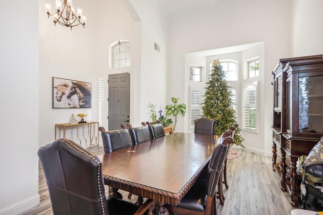 261 N Terry Ave, Clovis, CA 93612 - dining area featuring light wood-style floors, arched walkways, baseboards, a towering ceiling, and a chandelier