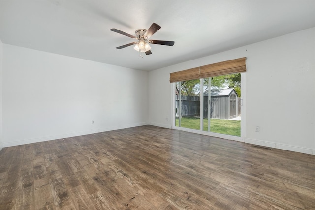 spare room featuring wood finished floors, ceiling fan, and baseboards