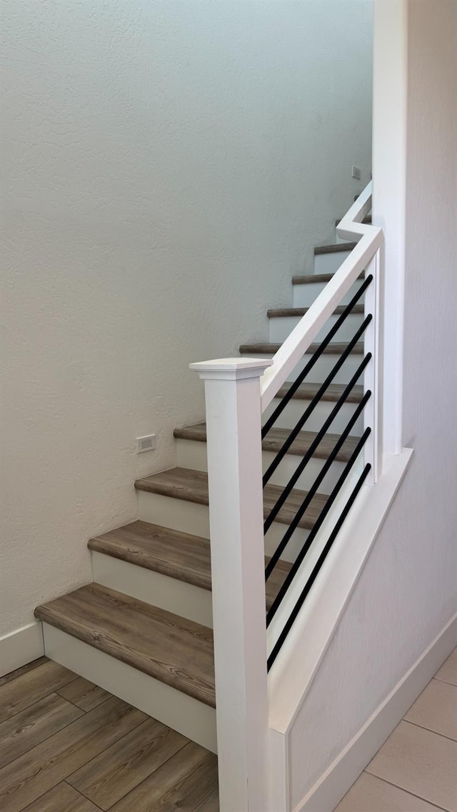 stairs with baseboards and wood finished floors