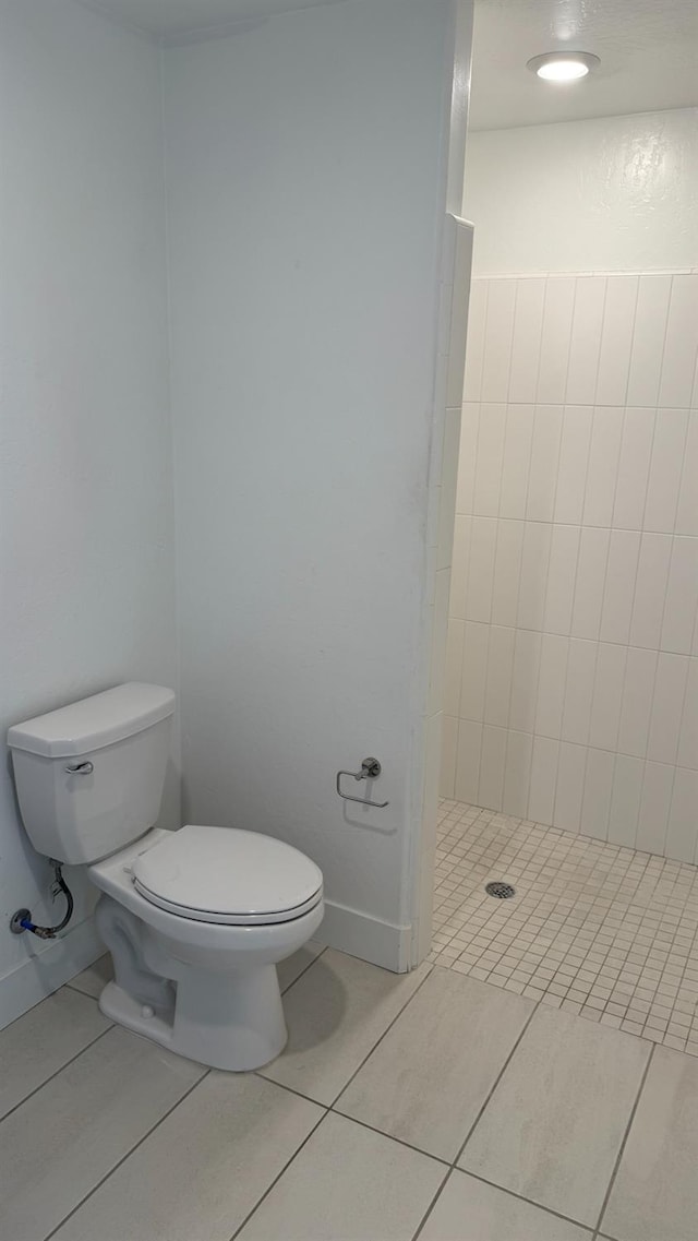 full bathroom featuring toilet, a shower stall, and tile patterned flooring