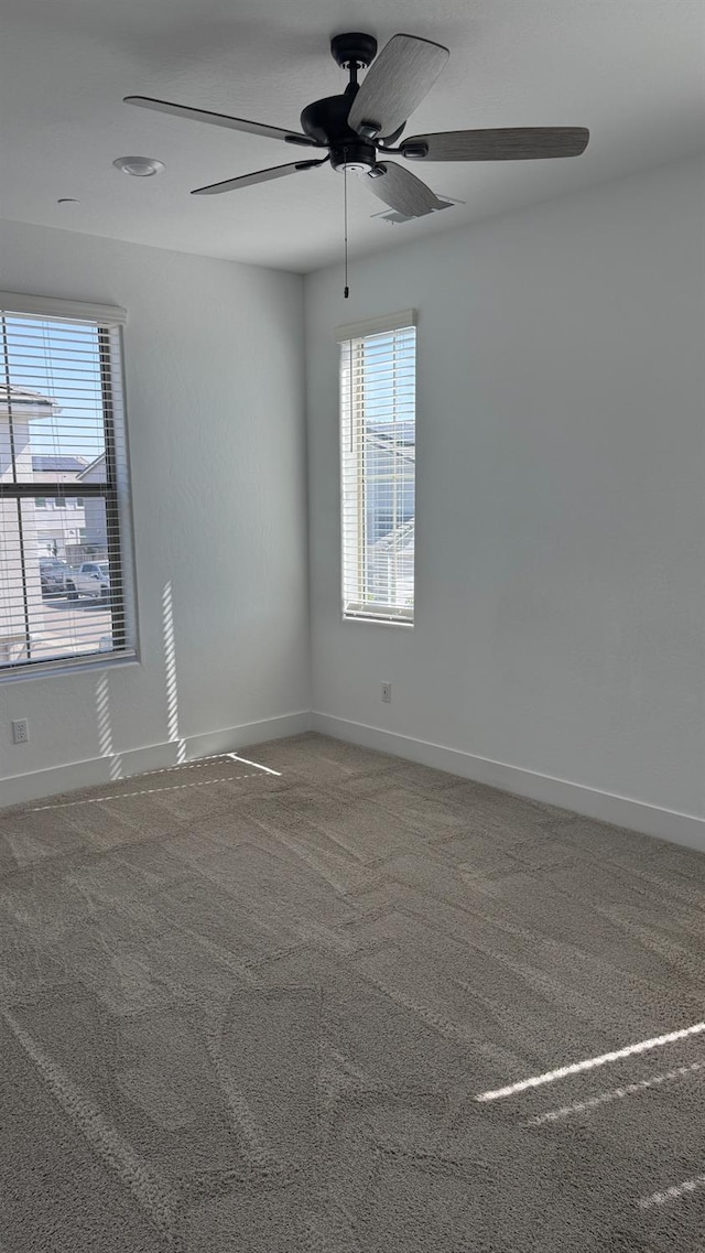 spare room featuring ceiling fan, baseboards, and carpet flooring