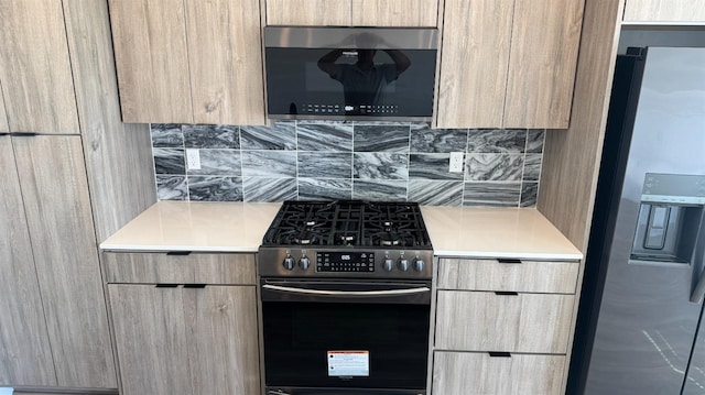 kitchen featuring appliances with stainless steel finishes, modern cabinets, decorative backsplash, and light countertops