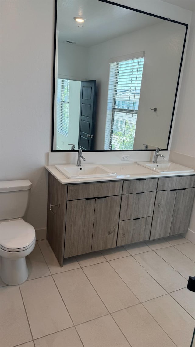 full bathroom with toilet, tile patterned floors, and double vanity