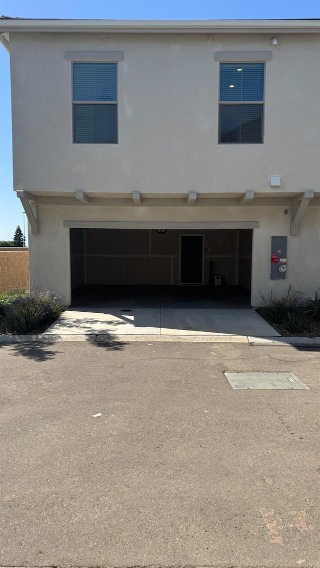 view of front of property with an attached garage, stucco siding, and driveway