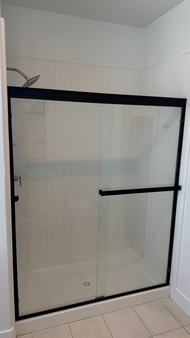 full bathroom featuring tile patterned flooring and a stall shower