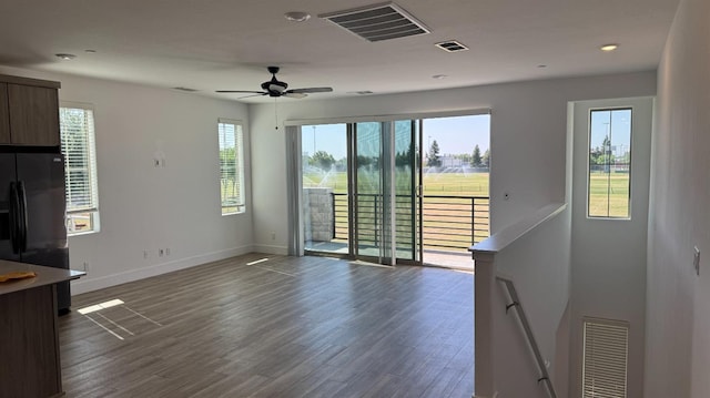 unfurnished living room with dark wood-style floors, baseboards, ceiling fan, and recessed lighting