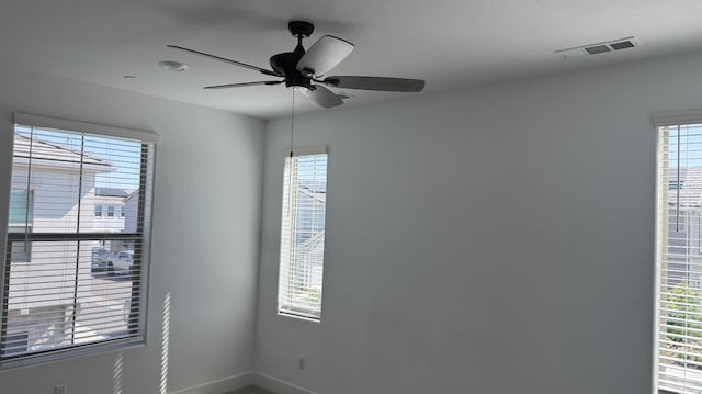 spare room featuring baseboards and a ceiling fan
