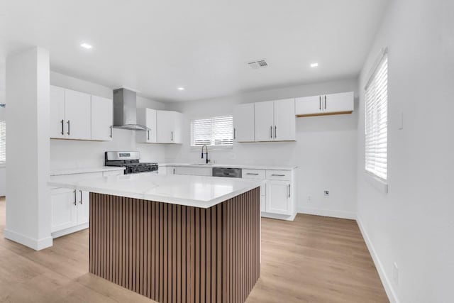424 W Menlo Ave, Clovis, CA 93612 - kitchen with wall chimney exhaust hood, stainless steel appliances, white cabinets, a kitchen island, and recessed lighting
